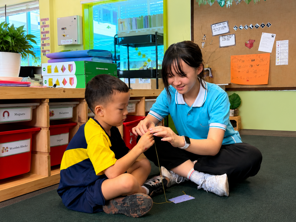 An Assistant Leader supporting younger learners during Co-Curricular Activities at Nexus International School Malaysia.